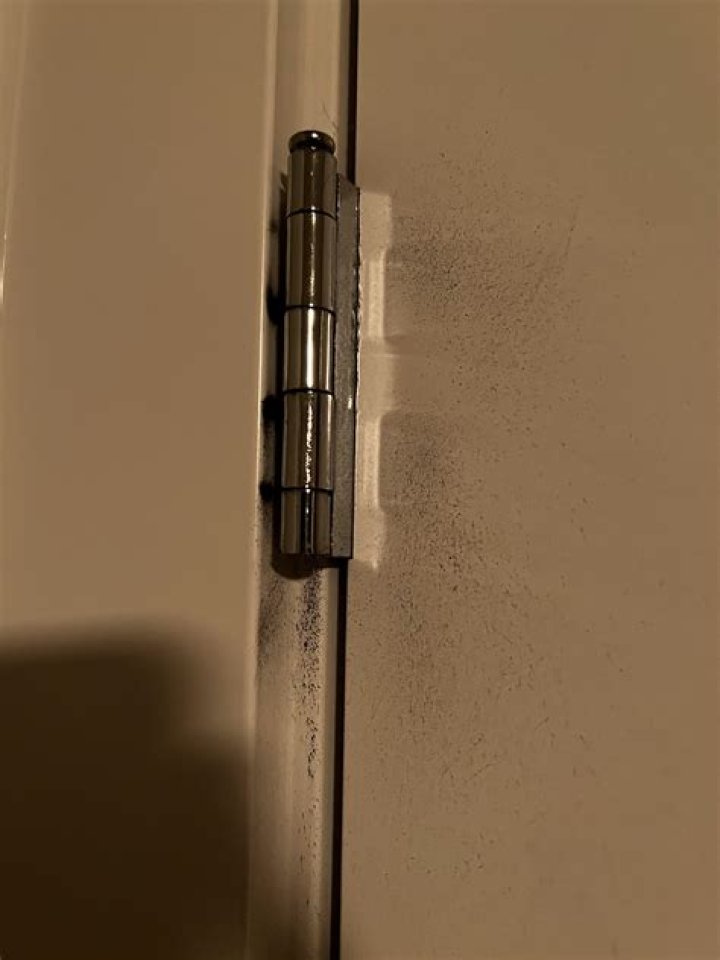 What causes black dust from door hinges